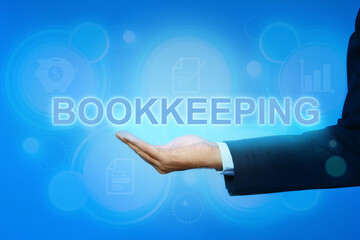 Bookkeeping concept. Businessman holding word on light blue background with digital icons, closeup