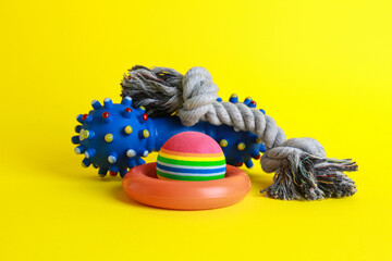 Different colorful pet toys on yellow background
