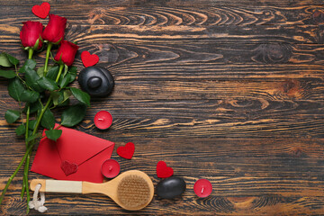 Beautiful spa composition for Valentine's Day with rose flowers, stones, brush, envelope and candles on wooden background