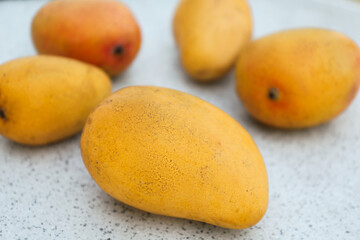 Delicious ripe juicy mangos on table, closeup