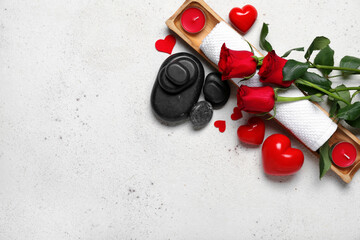 Beautiful spa composition for Valentine's Day with flowers, towel, hearts and stones on light background