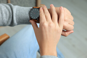 Man checking time in room, closeup. Being late