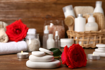 Fototapeta na wymiar Beautiful spa composition for Valentine's Day with stones, candles and rose flowers on wooden background