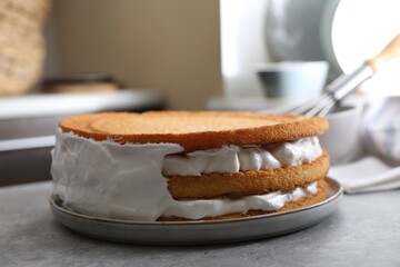 Delicious homemade layer cake with cream on grey table, closeup