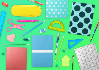 Flat lay composition with different school stationery on green background