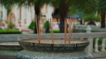 Close-up of a sandalwood incense stick slowly smoldering and releasing fragrant smoke into the air...