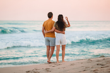 Young couple on the beach vacation in Florida at sunset - 555294128