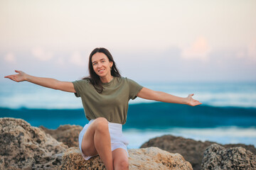 Young happy woman on the beach enjoy her summer vacation