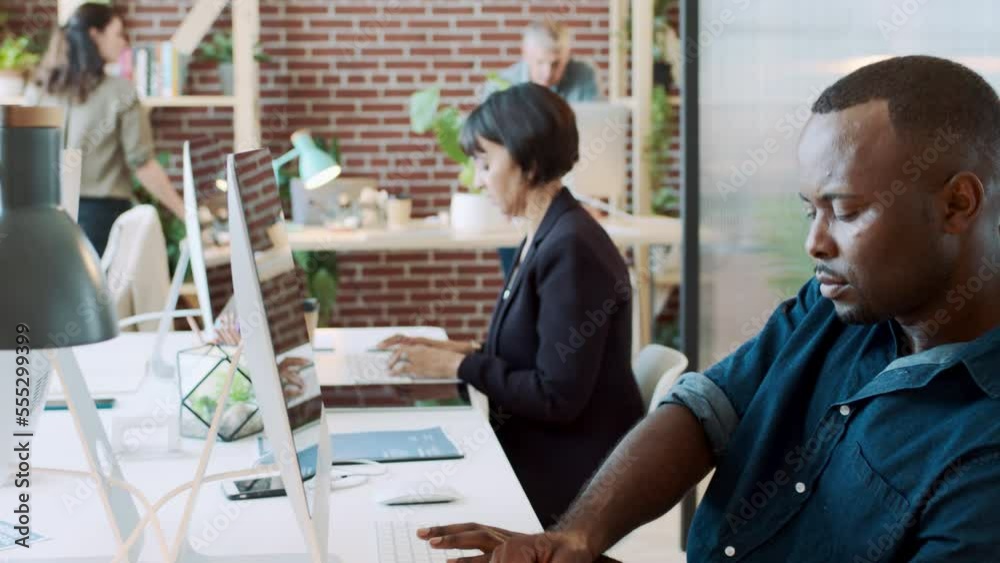 Poster black man, computer and coworking workplace with team working online and writing notes about data an