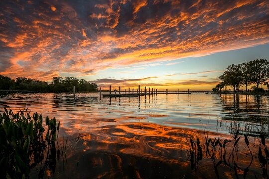 Fiery red and orange clouds and reflections on Lake Dora in Florida