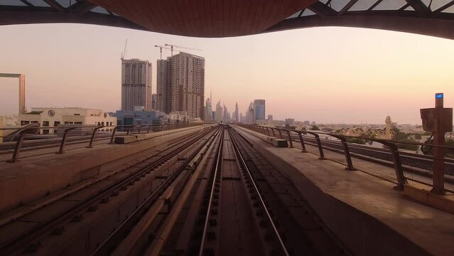 Dubai, UAE - 10th october, 2022: metro train on railway in Dubai with museum of future and futuristic buildings background. FPV POV At Fast Speed Drive Motion. driverless metro