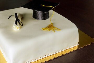 Cake with white fondant and decorations for graduation