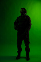 soldier in the studio on a green background with colored light. a man in military uniform with a gun, rifle or machine gun. military. airball player