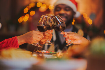 Glasses of champagne and wine in hands of people at party. happy friends or family having christmas dinner at home.