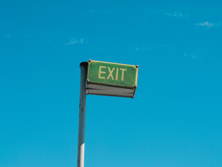 Exit sign against blue sky