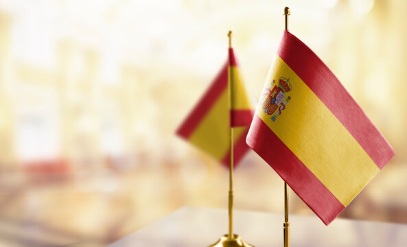 Small flags of the Spain on an abstract blurry background