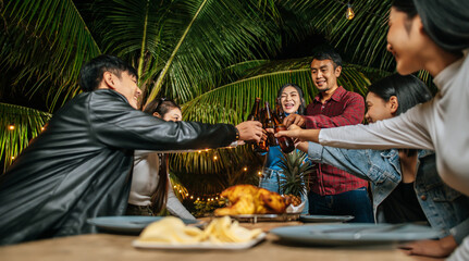 Portrait of Happy Asian friends having dinner party together - Young people sitting at bar table toasting beer glasses dinner outdoor  - People, food, drink lifestyle, new year celebration concept.