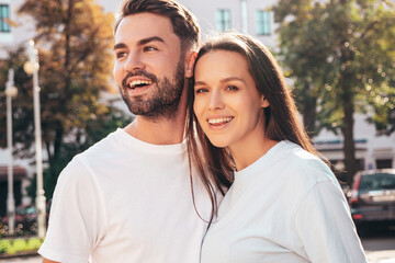 Obraz premium Smiling beautiful woman and her handsome boyfriend. Woman in casual summer jeans clothes. Happy cheerful family. Female having fun. Sexy couple posing in the street at sunny day