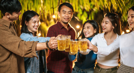 Portrait of Happy Asian friends having dinner party together - Young people toasting beer glasses dinner outdoor  - People, food, drink lifestyle, new year celebration concept.