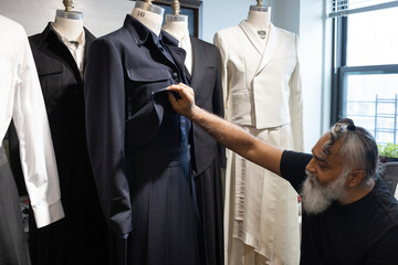 bearded man designing tailored fashion in his studio