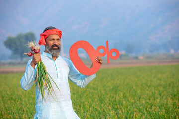 Indian farmer showing zero percent sign board at agriculture field.