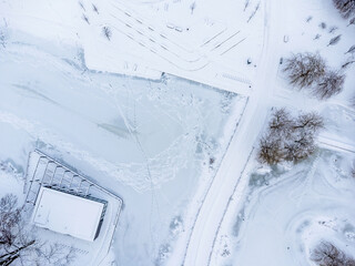 Aerial view. Winter landscape. Snow, frost, paths, trees, park, white powder.