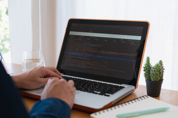 Programer developer coding software about intelligence innovation. Young man programmer writes program code on a computer. home office .