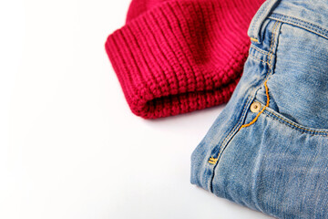 blue cotton jeans and raspberry wool sweater on white, banner concept, close-up