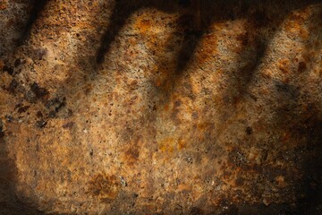 Rusty metal plate- corrosion on a dark red background. Abstract rust texture