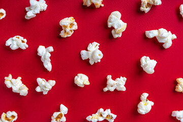 Scattered tasty cheese popcorn isolated on red background. Top view, flat lay , banner, wallpaper