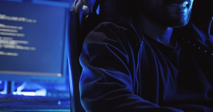 A male hacker is using a computer to hack data to demand ransom from victims.	