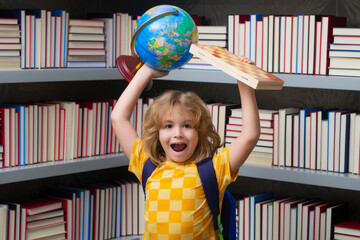 School boy with world globe and chess, childhood. School child studying in classroom at elementary school. Kid studying on lesson in class at elementary school.