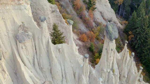 4k drone flight point of view (Ultra High Definition) of Earth pyramids of Platten - Spiky sand towers formed by water erosion and accessed by a woodland trail dotted with sculpture.