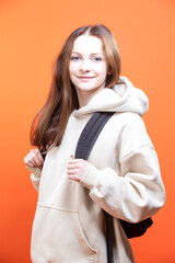 Winsome Student woman wearing Hoodie Jacket holding Black Board for Advertising Notes over isolated yellow background with a happy face standing and smiling with a confident smile