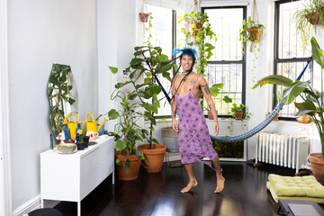 indigenous non-binary artist dancing at home surrounded by house plants
