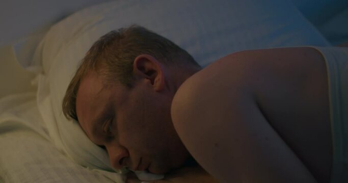 Guy falling in bed asleep at night after hard day, close-up shot