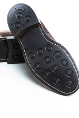Footwear Ideas. Closeup of Soles of Premium Dark Brown Grain Brogue Derby Boots Made of Calf Leather with Rubber Sole Placed Over One Another