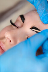 Microblading, micropigmentation eyebrows work flow in a beauty salon. Woman having her eye brows drawn and tinted. Semi-permanent makeup for eyebrows.