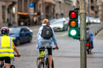 view of city traffic with traffic lights, in the foreground a semaphore with a green light, closeup