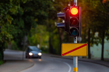 traffic semaphore with red light on defocused background of autumn city, closeup