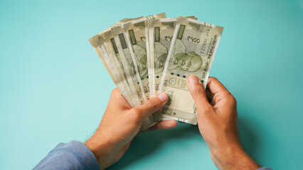 Unrecognizable hand counting five hundred Indian rupees, Close up of hand holding currency.