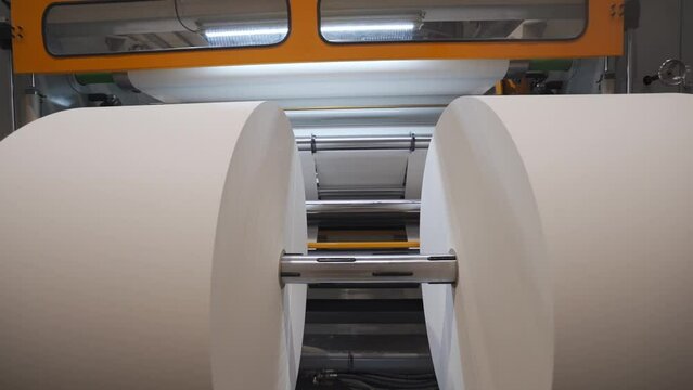 Huge Rolls Of Paper On Sliter-Rewinder Machine In A Factory. closeup, zoom-out