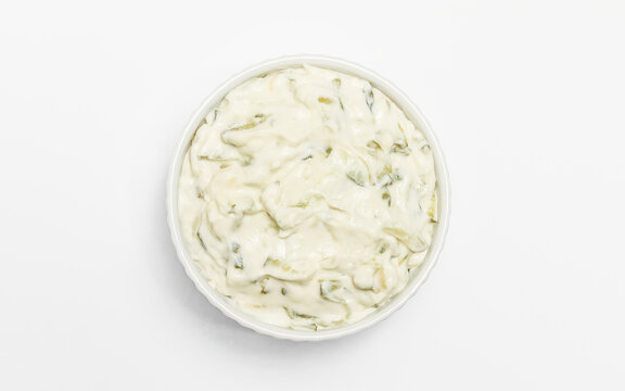 Isolated traditional greek yogurt sauce Tzatziki,dressing in white bowl, made of grated cucumbers, sour cream yogurt,olive oil,garlic,herbs on white background. Close up, flatly, horizontal