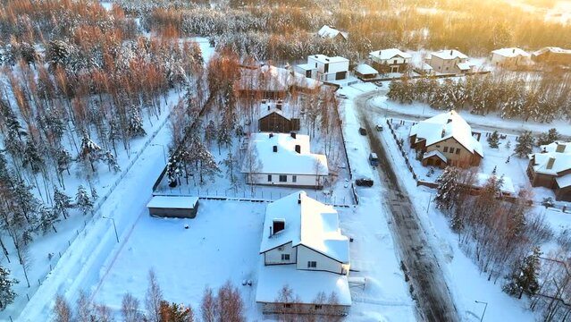 Cottage in winter sunset, aerial. Winter in town. Townhouse and Cottages in snow. Roofs houses in snow. Residential community in snowscape. Suburb House in winter snow. Snow covered rooftops.