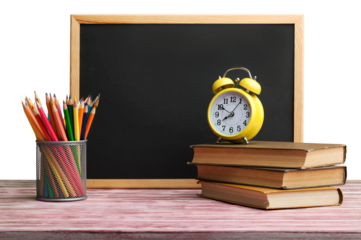 Stack of books with chalk blackboard and colored pencils on the wooden table.