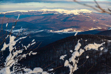 panorama of snow-capped mountains at sunset during a cold winter  mighty mountain peaks in the Polish Bieszczady mountains  mountain vegetation covered with snow © Lens Down Under