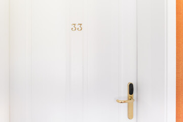 hotel room door number 33 with golden handle