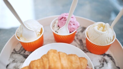 Ice cream and croissant with meat on the plate at the cafe.