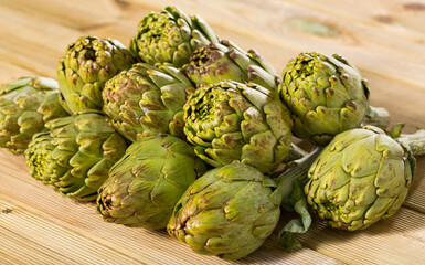 Fototapeta premium Fresh organic artichoke flowers on wooden table