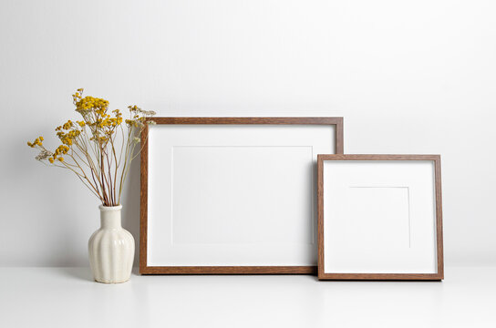 Blank wooden frames mockup in white scandinavian interior with dry flowers decor, copy space for artwork